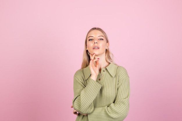 Jolie femme européenne en pull décontracté sur mur rose