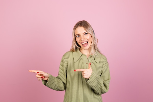 Jolie femme européenne en pull tricoté décontracté sur mur rose