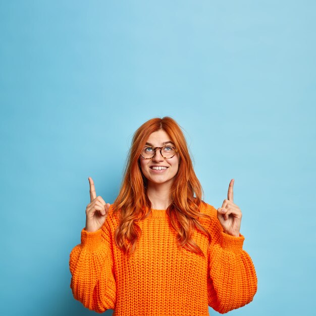 Jolie femme gaie a les cheveux rouges pointant au-dessus de l'espace