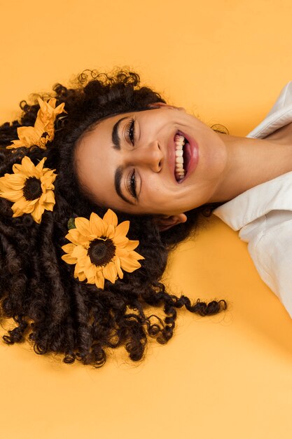 Jolie femme joyeuse avec des fleurs sur les cheveux