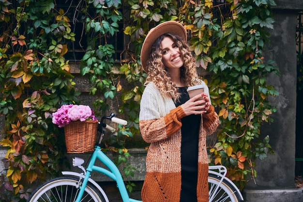 Jolie femme marchant dans le parc avec une boisson chaude