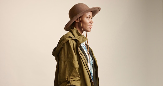 Jolie femme métisse aux cheveux courts en vêtements d'extérieur et chapeau d'automne