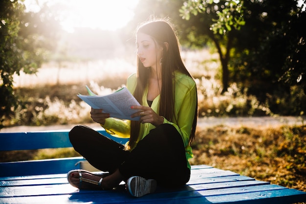 Jolie femme avec des papiers dans le parc