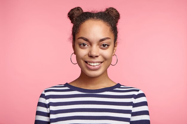 Jolie femme avec des petits pains de l'espace et une chemise rayée