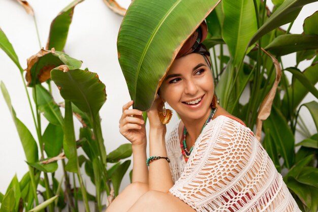 Jolie femme portant un foulard coloré comme un turban et de grandes boucles d'oreilles rondes