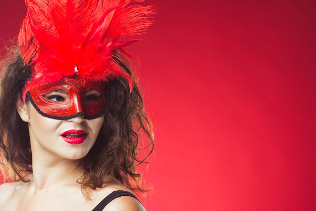 Jolie femme posant dans un masque rouge