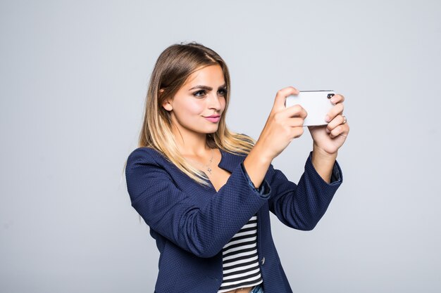 Jolie femme prend des photos avec son téléphone portable