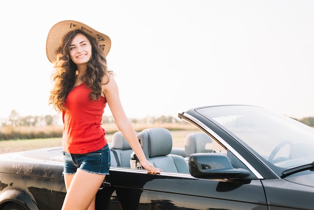 Jolie femme près du cabriolet