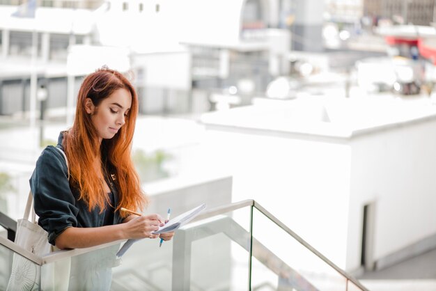 Jolie femme qui écrit sur les escaliers