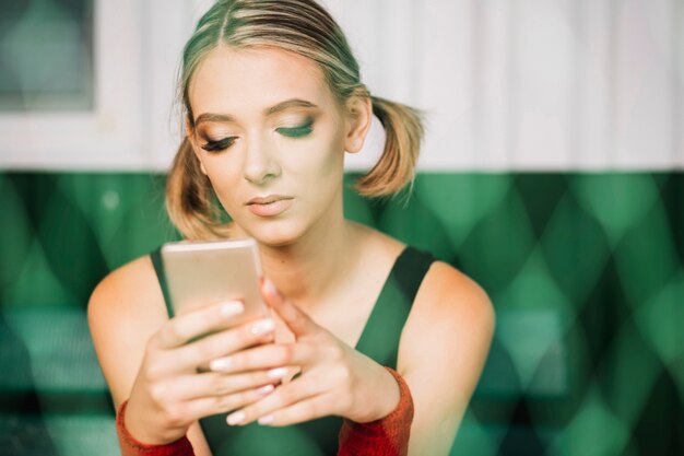 Jolie femme à la recherche dans son téléphone sur le terrain de tennis