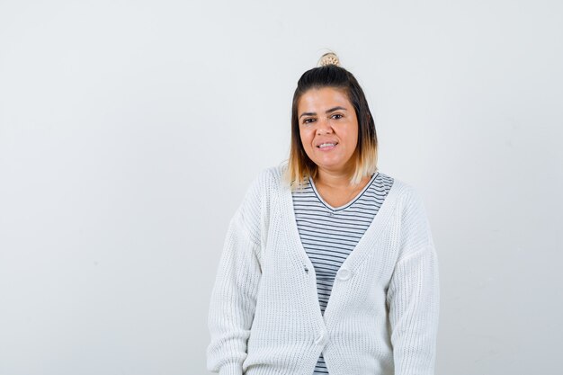 Jolie femme regardant la caméra en t-shirt, cardigan et semblant brillante