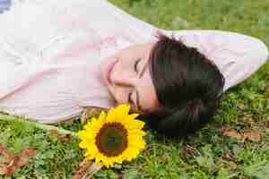 Photo gratuite jolie femme rêvant et couchée sur l'herbe