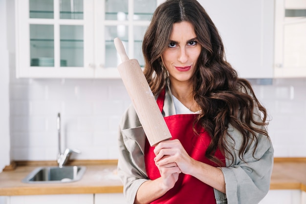 Photo gratuite jolie femme avec un rouleau à pâtisserie