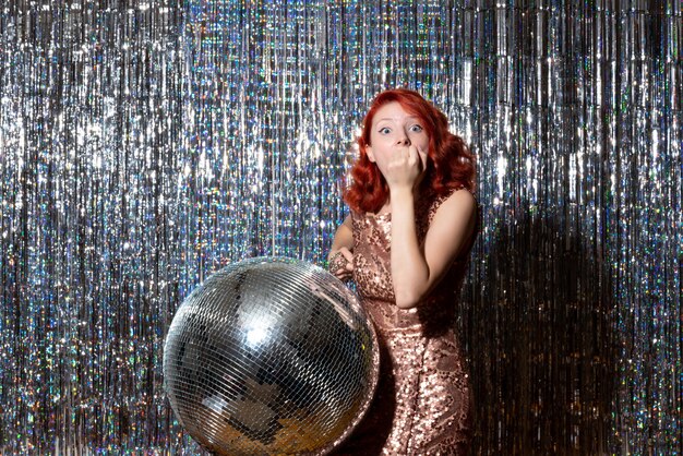 Jolie femme en soirée disco sur des rideaux lumineux