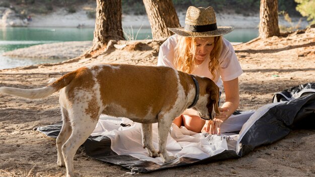 Jolie femme et son chien mettant la tente