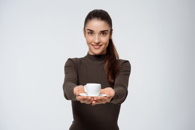 Jolie femme souriante donne du café