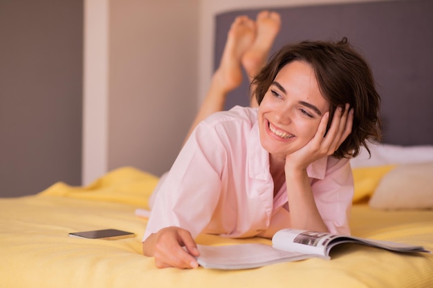 Jolie femme souriante regarde loin à la maison