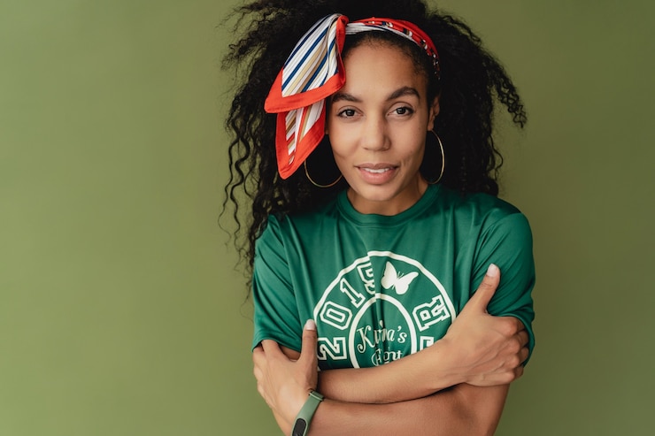 Photo gratuit jolie femme en t-shirt et short élégant tenue hipster sur le mur vert du studio