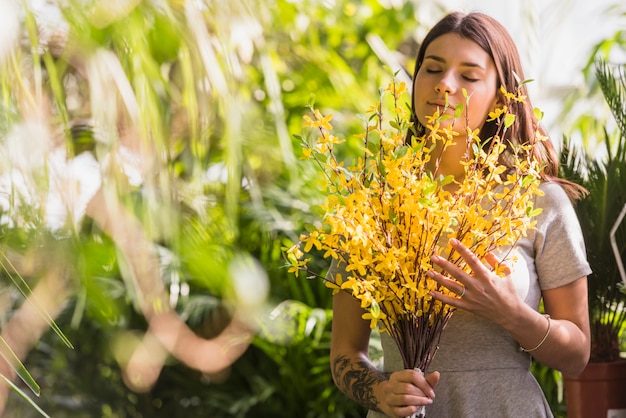 Jolie femme tenant un bouquet de brindilles