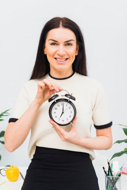 Jolie femme tenant une horloge à 7 heures