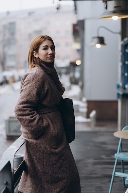 Photo gratuite jolie femme en trench-coat sur la rue de la ville