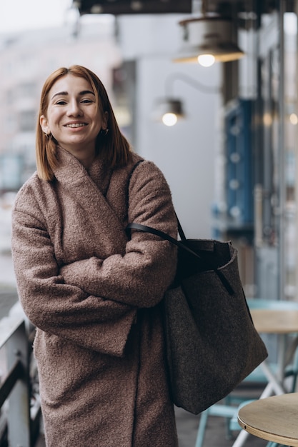 Jolie femme en trench-coat sur la rue de la ville