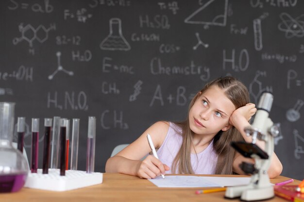 Jolie fille en apprenant plus sur la chimie en classe