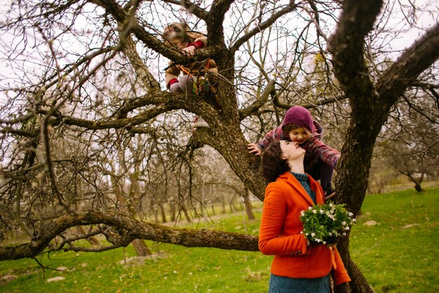 La jolie fille assise sur l&#39;arbre et la mère en regardant sa fille