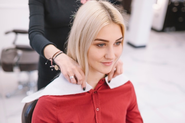 Photo gratuite jolie fille assise dans un salon de coiffure