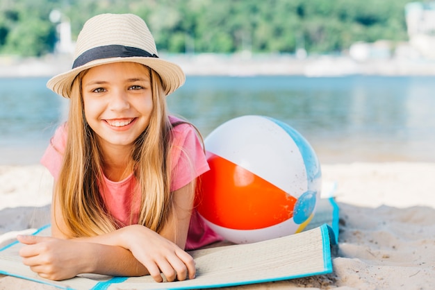 Jolie fille avec ballon souriant sur la côte