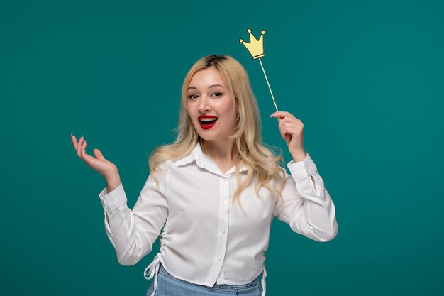 Jolie fille blonde belle jeune fille dans une chemise blanche soignée heureuse et joyeuse avec une fausse couronne