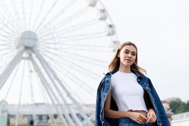 Photo gratuite jolie fille blonde et grande roue à l'extérieur