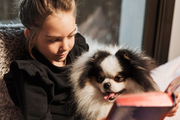 Jolie fille et chien lisant