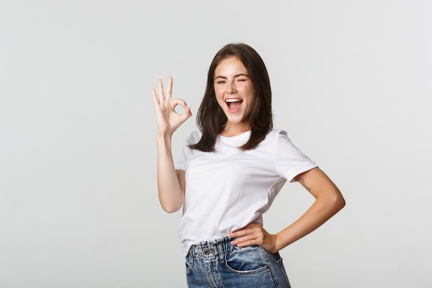 Jolie fille confiante et optimiste montrant le geste du pouce vers le haut en approbation.