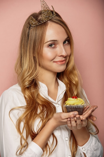 Photo gratuite jolie fille avec une couronne et un cupcake