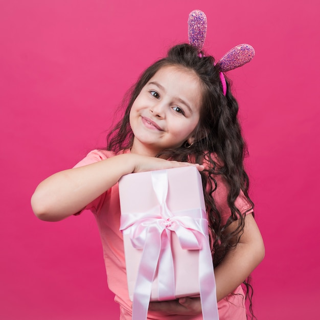 Jolie fille dans des oreilles de lapin avec une boîte cadeau