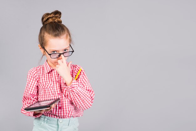 Jolie fille dans des verres debout avec tablette