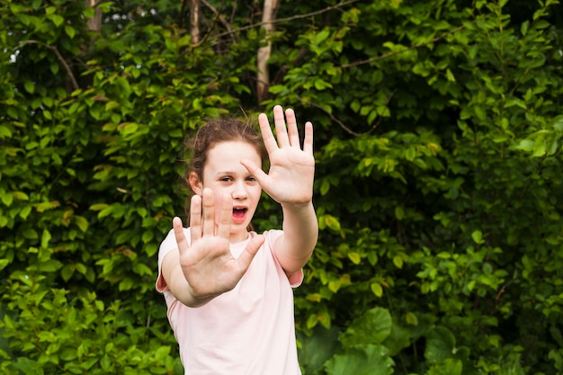 Jolie fille, debout, dans, parc, projection, signe stop