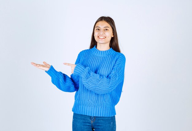 jolie fille debout et pointant sur blanc.