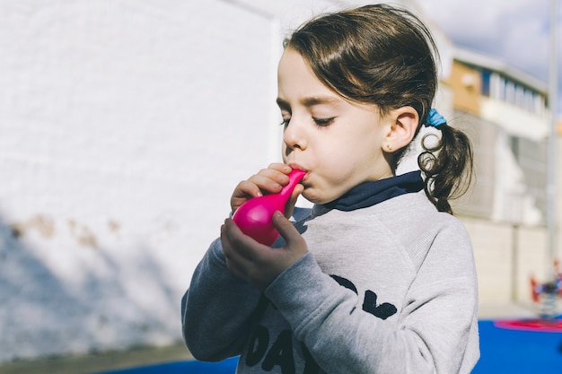 Jolie fille essayant de faire exploser un ballon