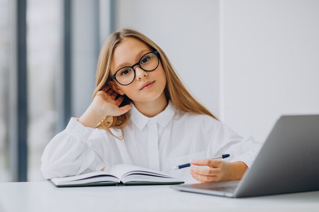 Jolie fille étudie sur l'ordinateur à la maison