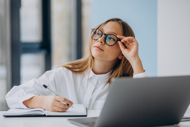 Jolie fille étudie sur l'ordinateur à la maison