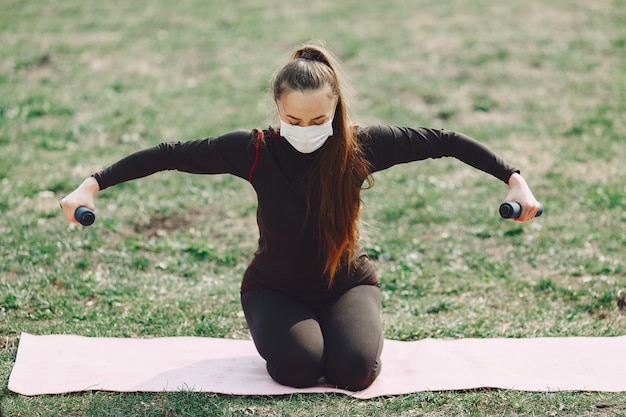 Jolie fille faisant du yoga dans un parc d'été