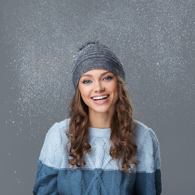 Jolie fille avec des flocons de neige s'amuser