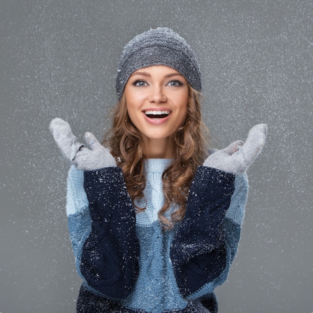 Jolie fille avec des flocons de neige s'amuser