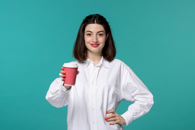 Jolie fille jolie brune jeune fille douce en chemise blanche donnant une tasse de papier rose