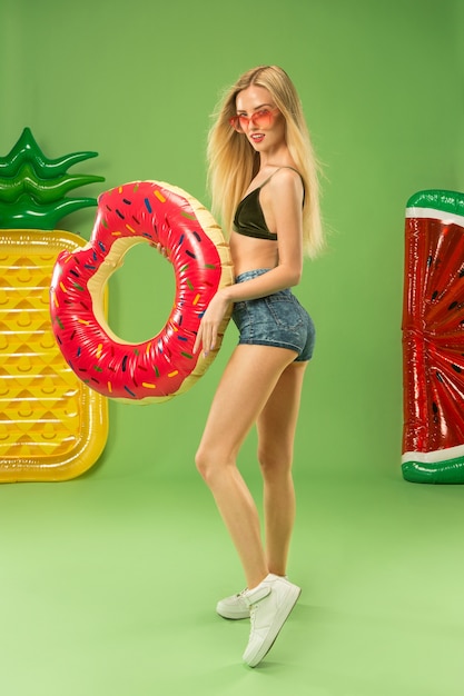 Jolie Fille En Maillot De Bain Posant Au Studio Avec Cercle De Natation Gonflable. Portrait D'été Adolescent Caucasien Sur Vert