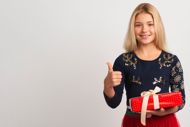 Jolie fille montrant les pouces vers le haut de l'espace de copie