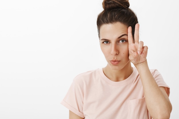 Photo gratuite jolie fille posant contre le mur blanc