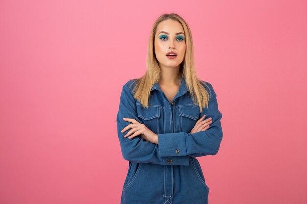 Jolie fille posant sur fond rose dans la tendance de la mode globale denim